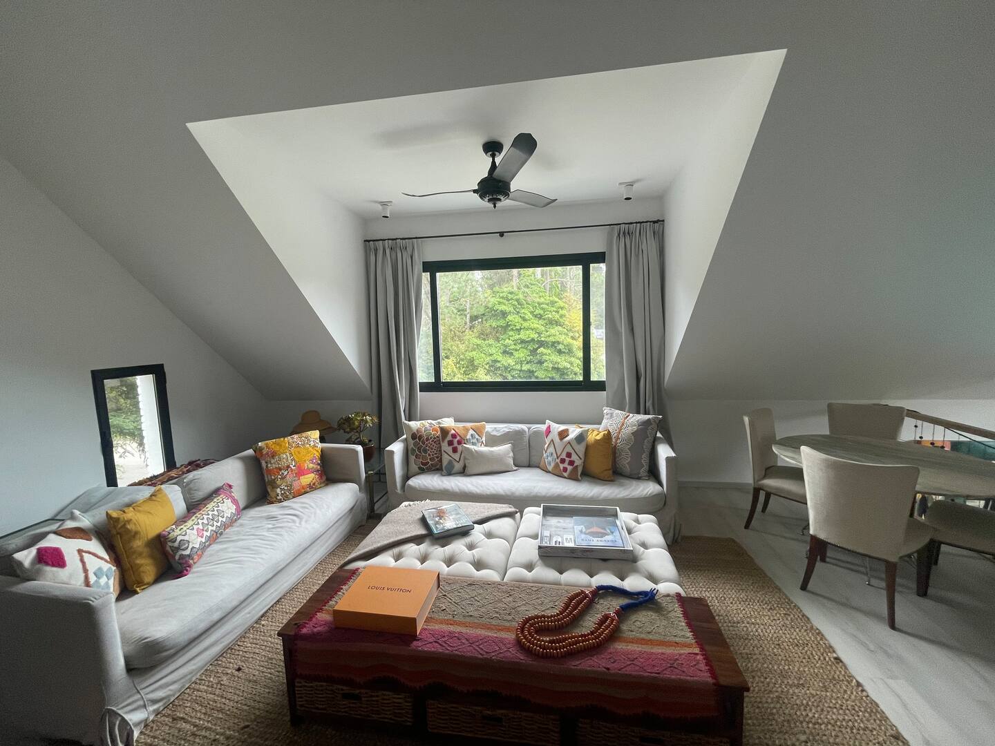 First floor living room with sofas, marble dining table and garden view