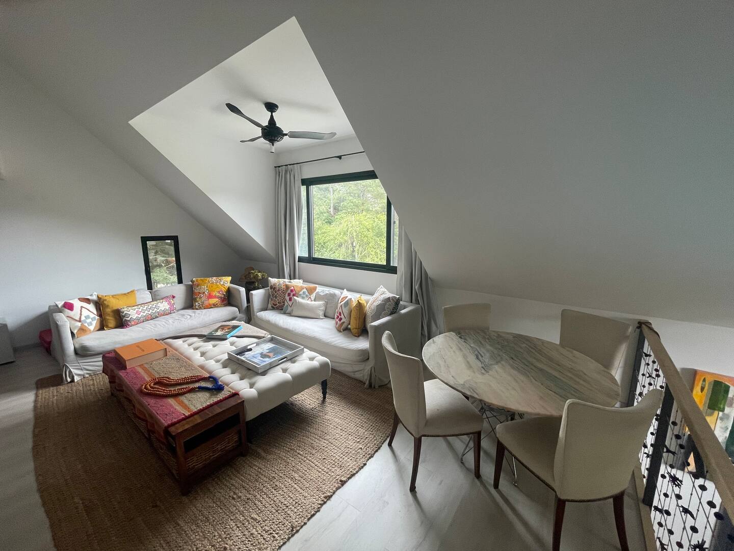 First floor living room with two sofas, dining nook and garden window