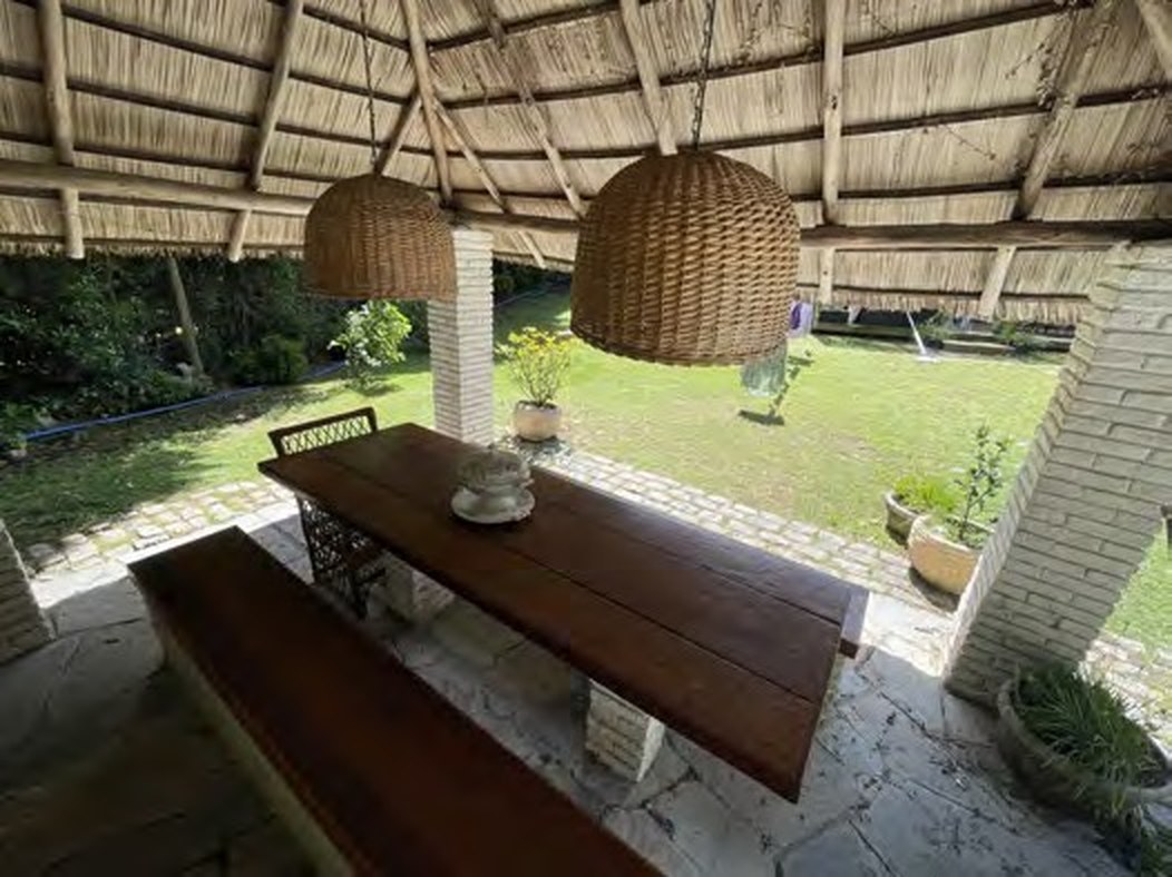 Quincho with long wooden table and wicker pendant lamps